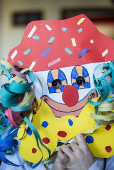 portrait of a 6 year old boy with a carnival mask made by himself at home