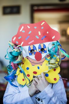 portrait of a 6 year old boy with a carnival mask made by himself at home