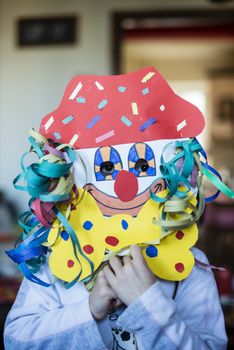 portrait of a 6 year old boy with a carnival mask made by himself at home