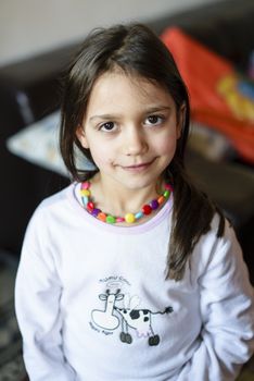 portrait of a 5 year old girl wearing pajamas in her home in the hall