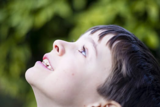 portrait of 7 year old boy outdoor in the garden in winter