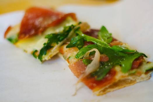 Pizza strip on white background, with rocetta salad and ham