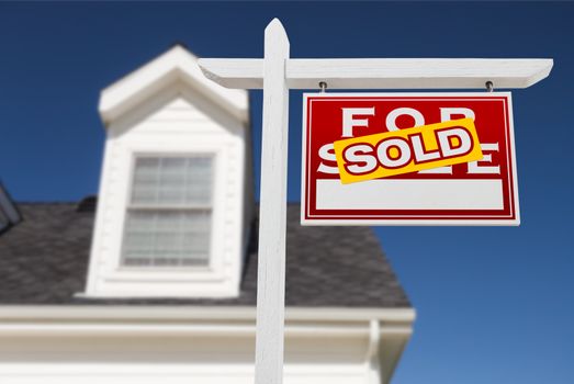 Right Facing Sold For Sale Real Estate Sign In Front of House and Deep Blue Sky.