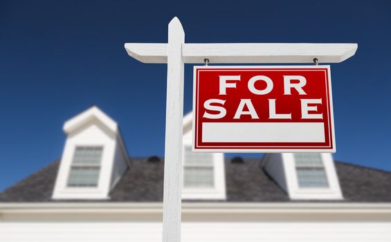 Right Facing For Sale Real Estate Sign In Front of House and Deep Blue Sky.