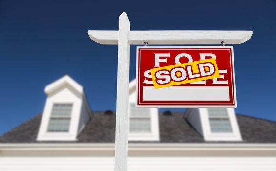 Right Facing Sold For Sale Real Estate Sign In Front of House and Deep Blue Sky.