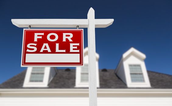 Left Facing For Sale Real Estate Sign In Front of House and Deep Blue Sky.