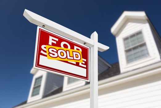 Left Facing Sold For Sale Real Estate Sign In Front of House and Deep Blue Sky.