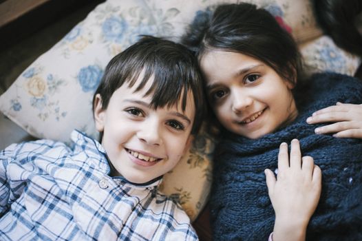 portrait of brothers in pajamas at home lying on the ground smiling