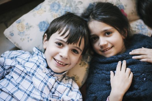 portrait of brothers in pajamas at home lying on the ground smiling