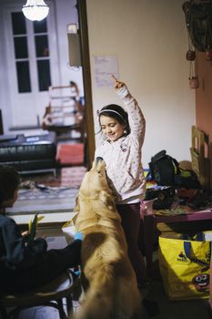 little girl at home with her golden retriever dog have affectionate gestures