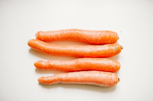 still-life photograph of carrots on white background