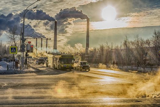 cars on the background of smoke from factories winter day steam from cold