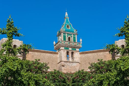 Beautiful view. Tower of the Monastery of Valldemossa in the Sierra de Tramuntana Mountains with park.