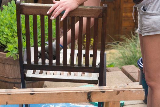 Painting and applying protective varnish on a wooden garden chair