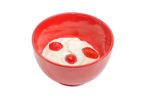 Fresh berries of the strawberry with whipped cream in red ceramic bowl on a light background
