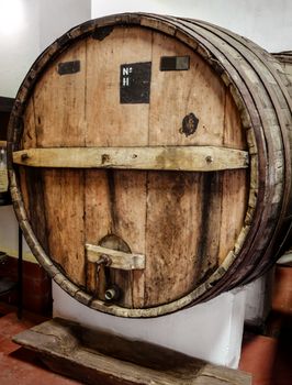 rows of wood wine barrels in a vintage winery cave