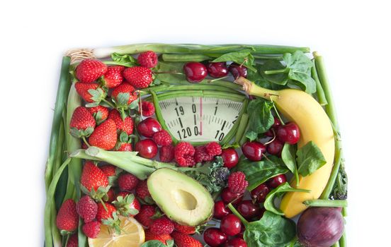 Weighing scales made from fruits and vegetables over a white background
