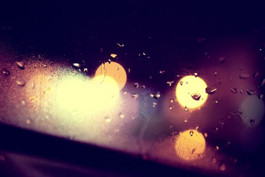 Wet window background and city lights.Rainny night through the glass