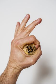 bitcoin electronic coin holding in the hand white background