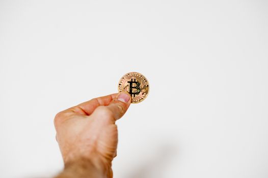 bitcoin electronic coin holding in the hand white background