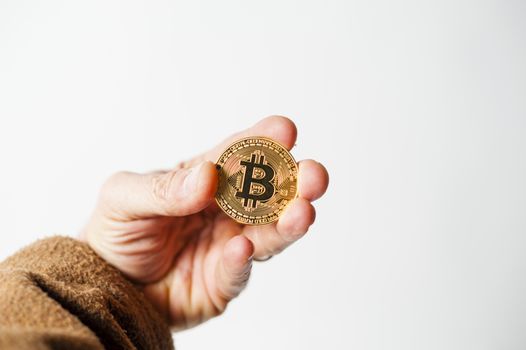 bitcoin electronic coin holding in the hand white background