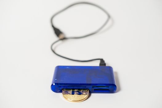 bitcoin electronic coin inside a digital card reader, white background