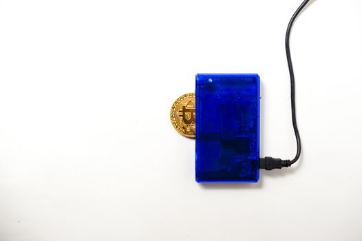 bitcoin electronic coin inside a digital card reader, white background