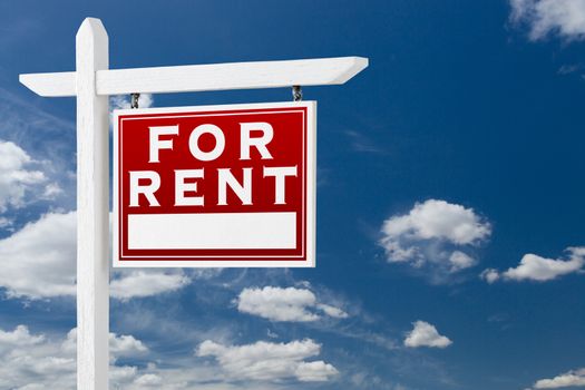 Right Facing For Rent Real Estate Sign Over Blue Sky and Clouds With Room For Your Text.