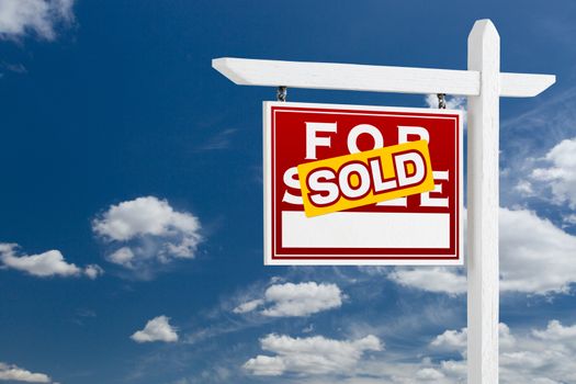 Left Facing Sold For Sale Real Estate Sign Over Blue Sky and Clouds With Room For Your Text.