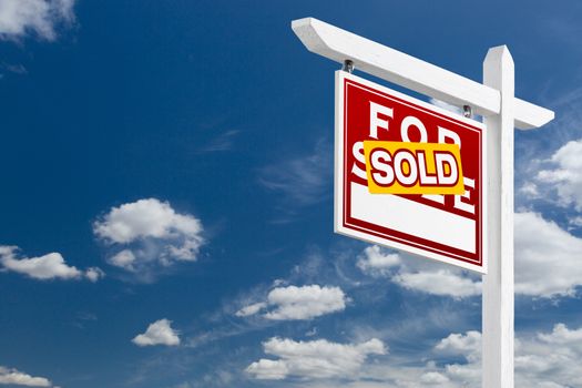 Left Facing Sold For Sale Real Estate Sign Over Blue Sky and Clouds With Room For Your Text.