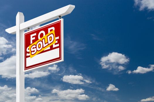 Right Facing Sold For Sale Real Estate Sign Over Blue Sky and Clouds With Room For Your Text.
