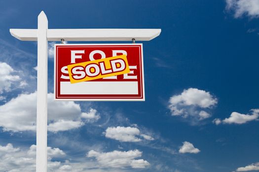 Right Facing Sold For Sale Real Estate Sign Over Blue Sky and Clouds With Room For Your Text.