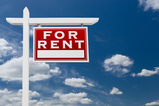 Right Facing For Rent Real Estate Sign Over Blue Sky and Clouds With Room For Your Text.