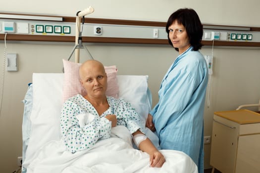 middle age woman patient with cancer in hospital on oncology department visited by her girlfriend. She hope in healing.