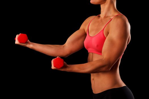 Sporty young woman with dumbbells isolated on black background, closeup shot
