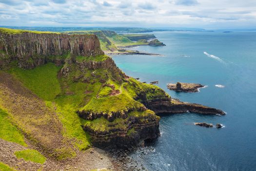 view on Amphitheatre, Port Reostan Bay and Port Noffer Bay with Giant's Causeway on background, County Antrim, Northern Ireland, UK