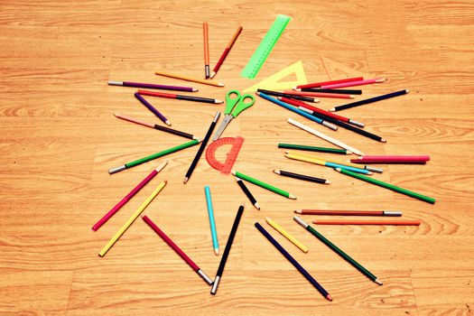 Scattered on the floor chaotically colored pencils, scissors and measuring .