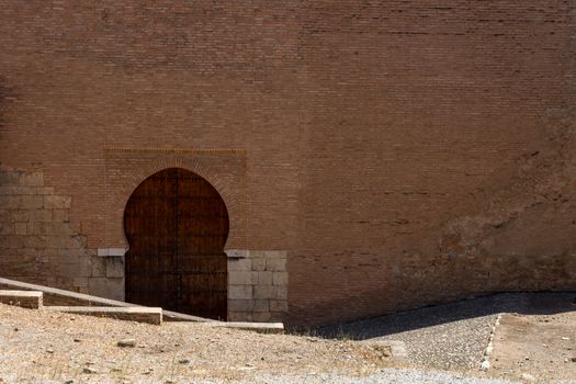 Moorish Islamic Arch above a wooden door in Granada, Spain, Europe on a bright sunny day