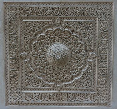 closeup of a wall of white plaster with arabic design in Alhambra, Granada, Spain, Europe on a bright summer day