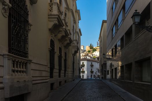 cobble stone street in the city of Granada, Spain, Europe during golden hour of sunset on a bright sunny day