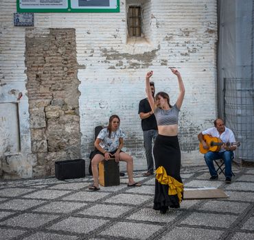 GRANADA, SPAIN - JUNE 23: Unidentified flamenco dancer dances for tourists in St. Nicolas viewpoint to Alhambra in Granada on June 23, 2017 in Spain