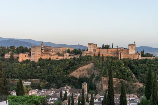 The magnificient Alhambra of Granada, Spain. Alhambra fortress at sunset viewed from Mirador de San Nicolas during evening twilight hour.