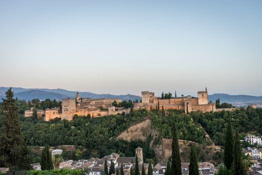 The magnificient Alhambra of Granada, Spain. Alhambra fortress at sunset viewed from Mirador de San Nicolas during evening twilight hour.