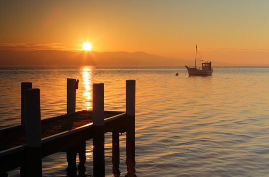 Misty morning and golden orange sunrise with aptly named boat seamist bobbing on its mooring.