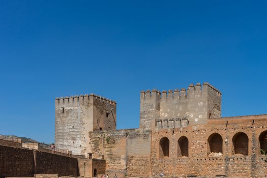 Ruins of former ancient fortress Alhambra. Military house, Granada, Andalusia, Spain, Europe on a bright sunny day with clear blue skiy