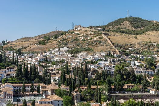 Hillside view of the city of Granada, Albaycin , viewed from the Alhambra palace in Granada, Spain, Europe on a bright summer day with blue sky