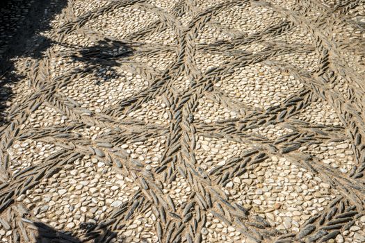 Circular patterns on a stone walking path at the Alhambra palace in Granada, Spain, Europe on a bright summer day