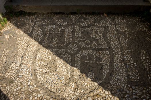 Shield patterns on a stone walking path at the Alhambra palace in Granada, Spain, Europe on a bright summer day