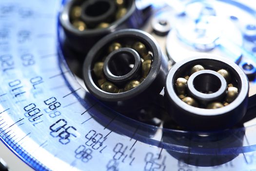 Engineering concept. Ball bearings set closeup on blue transparent protractor