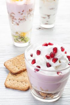 Natural homemade yogurt with fruits on a white wooden background, selective focus